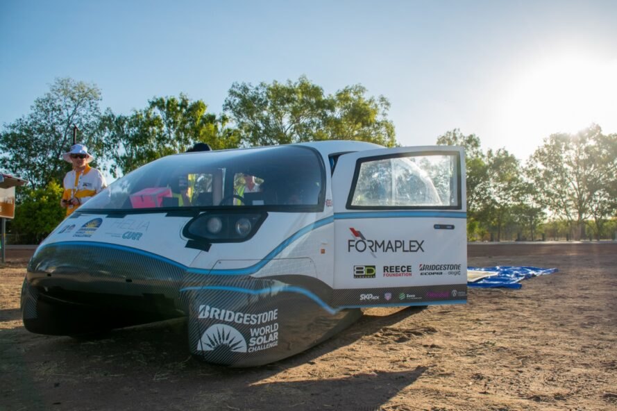 white electric car with sponsor logos painted on the body